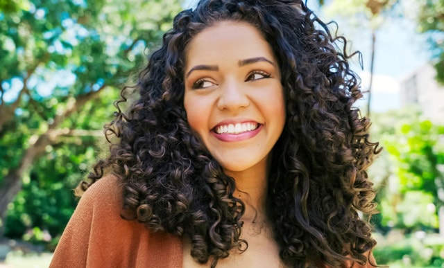 Female with curly hair smiling